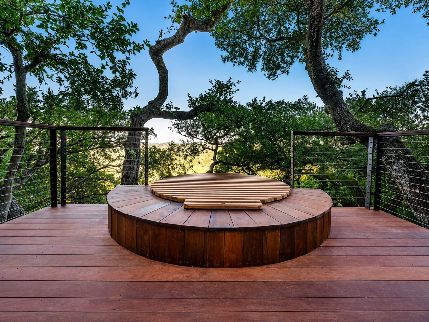 Hardwood deck with a raised circular hot tub surround and cable balustrade by McGibbon Construction