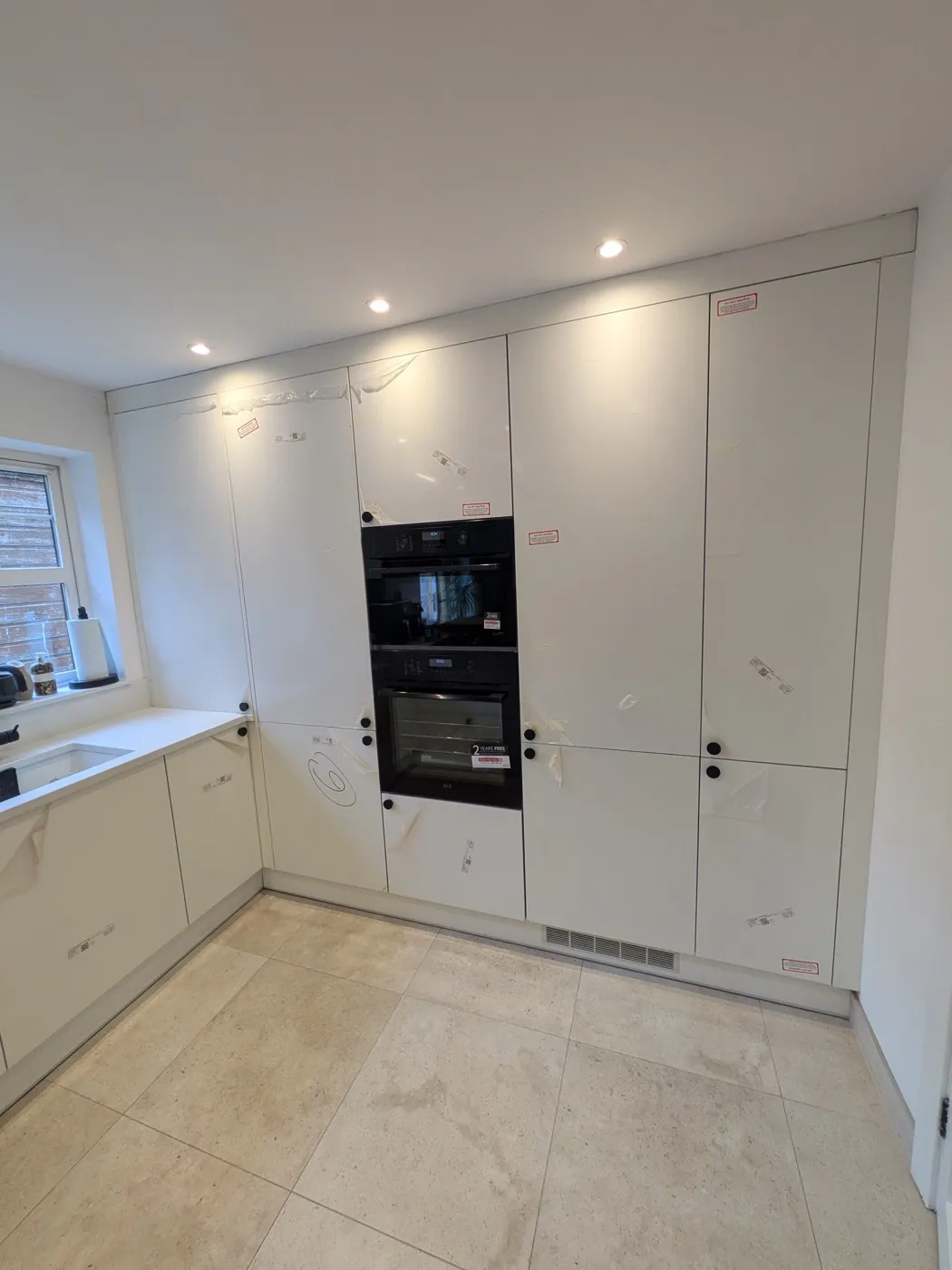 Cream kitchen with a wall of tall units housing a built-in oven and microwave